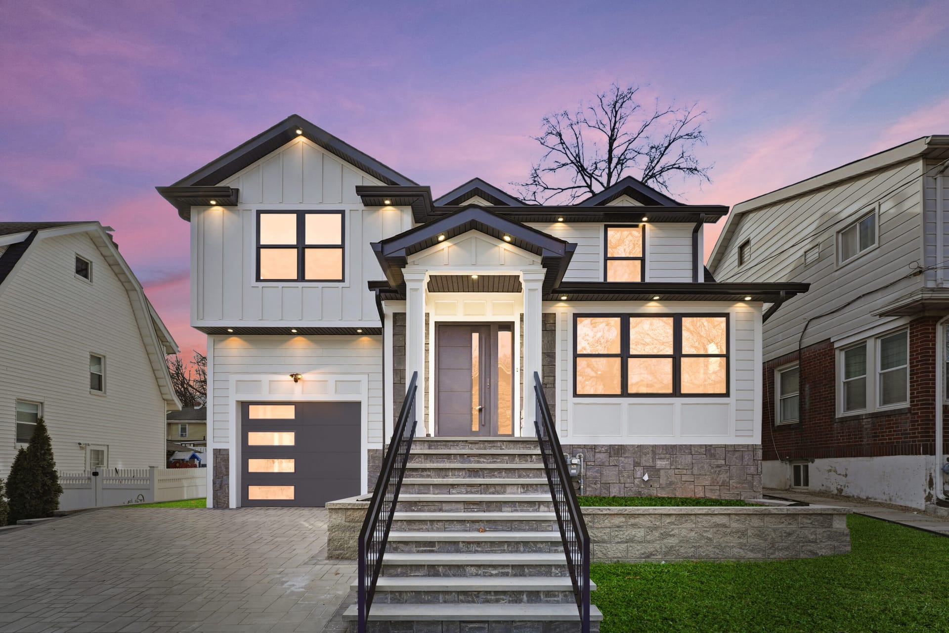 Front exterior of 820 Elm Avenue at dusk — a renovated modern farmhouse with stone accents and a covered entry