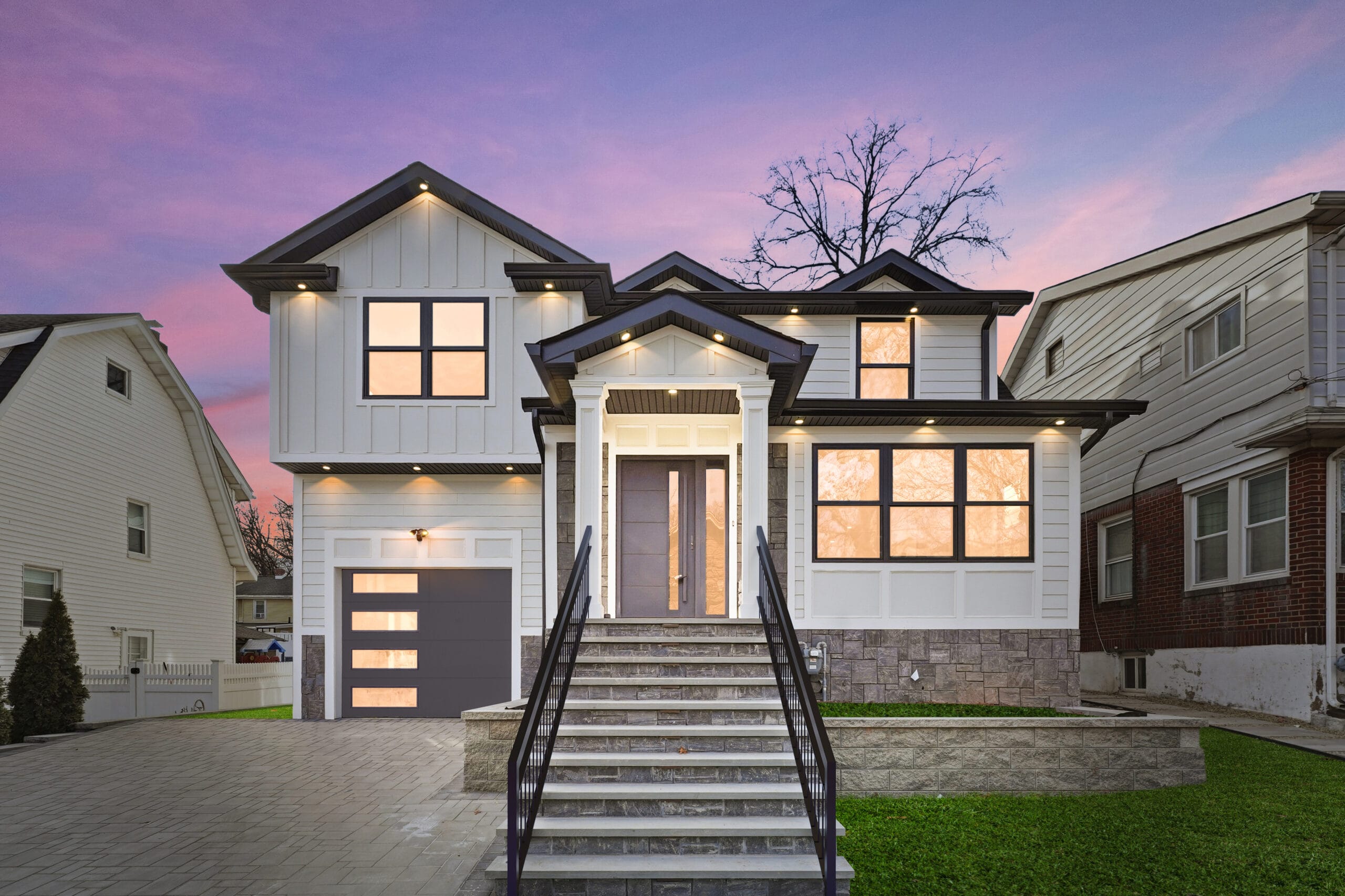 Front exterior of 820 Elm Avenue at dusk — a renovated modern farmhouse with stone accents and a covered entry