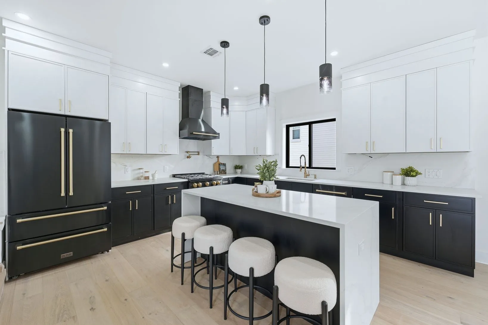 Fully renovated chef’s kitchen at 820 Elm Avenue with black cabinetry, brushed gold hardware, and a waterfall quartz island