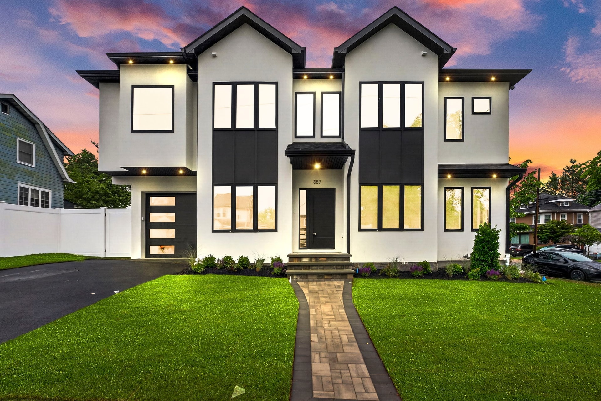 887 Linden Avenue at twilight — a modern two-story home with white stucco, black trim, and soffit lighting
