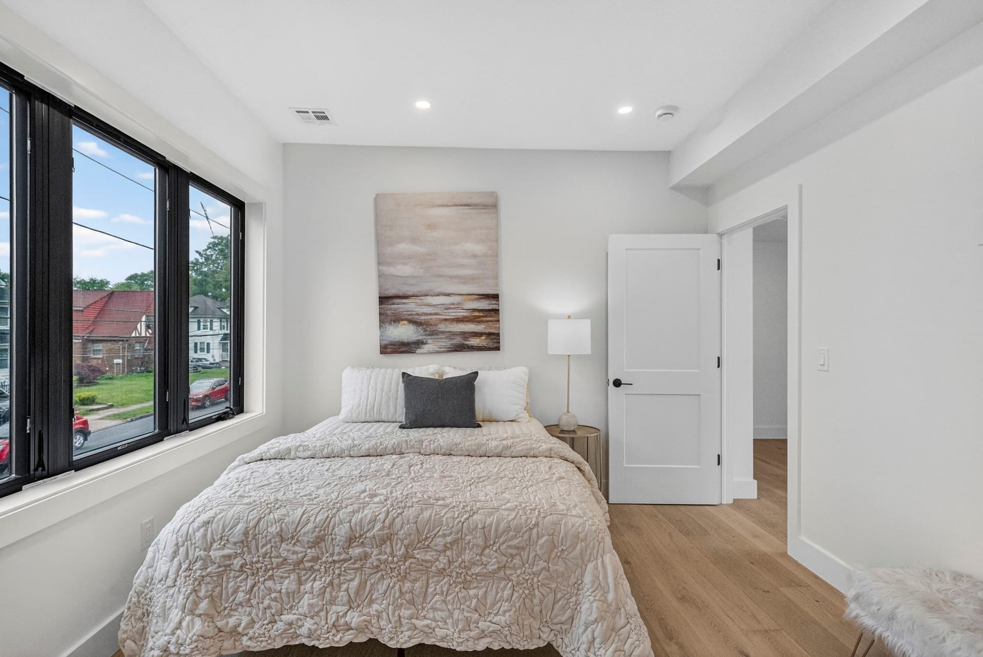 Bedroom with corner windows and framed abstract artwork