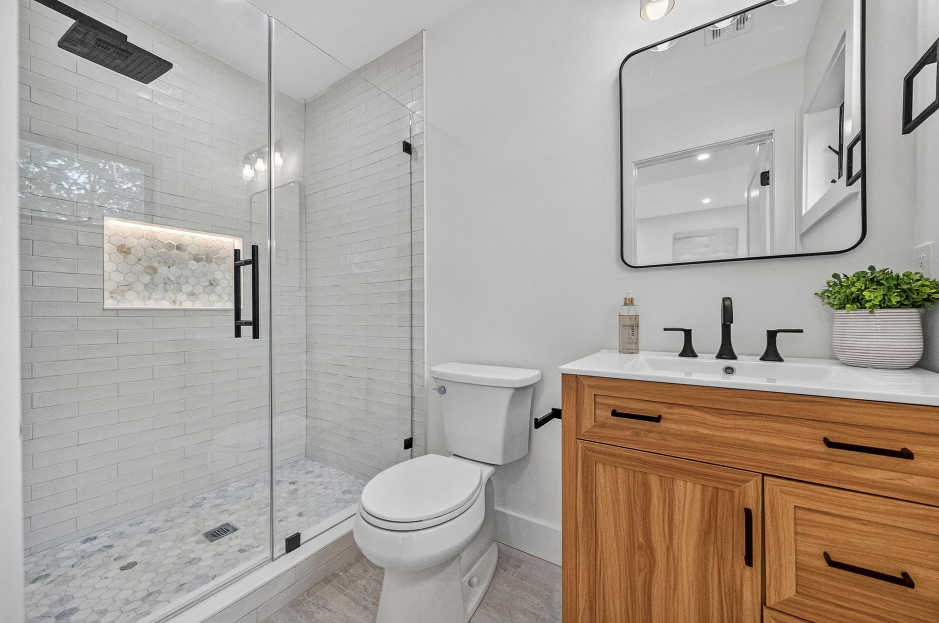 Bathroom with a glass-enclosed shower, subway tile, and a wood vanity