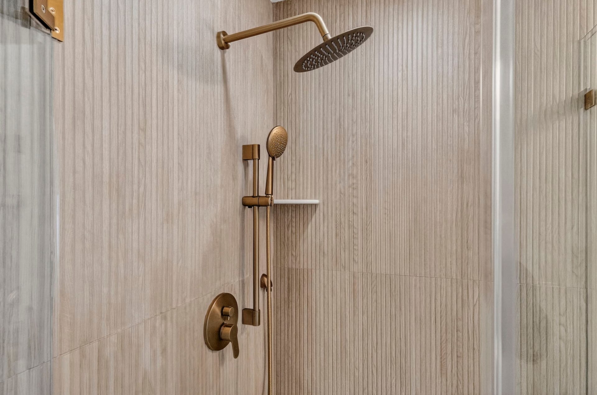 Detail of a brass rain shower head and hand-shower fixtures