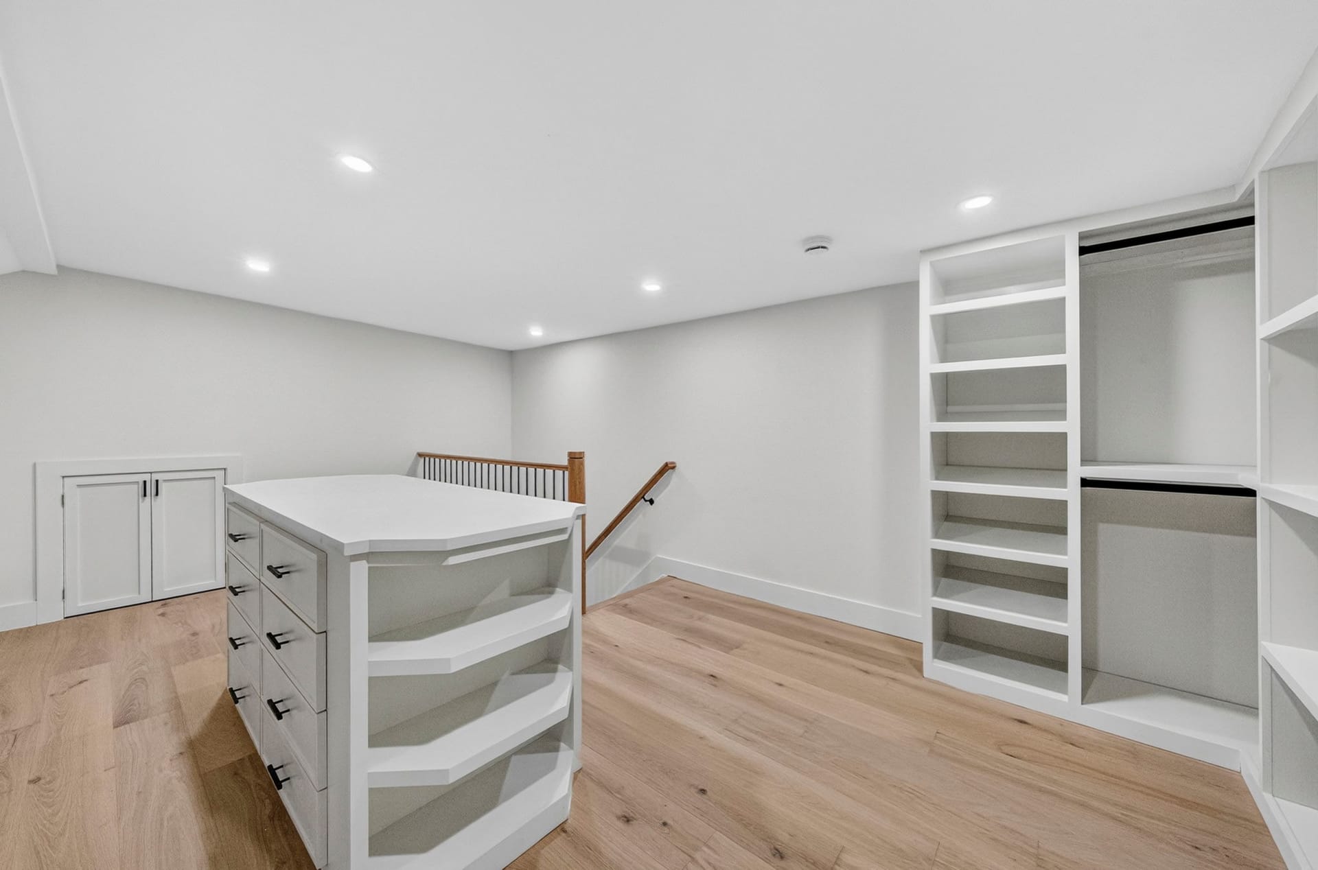 Walk-in closet with built-in drawers overlooking the staircase