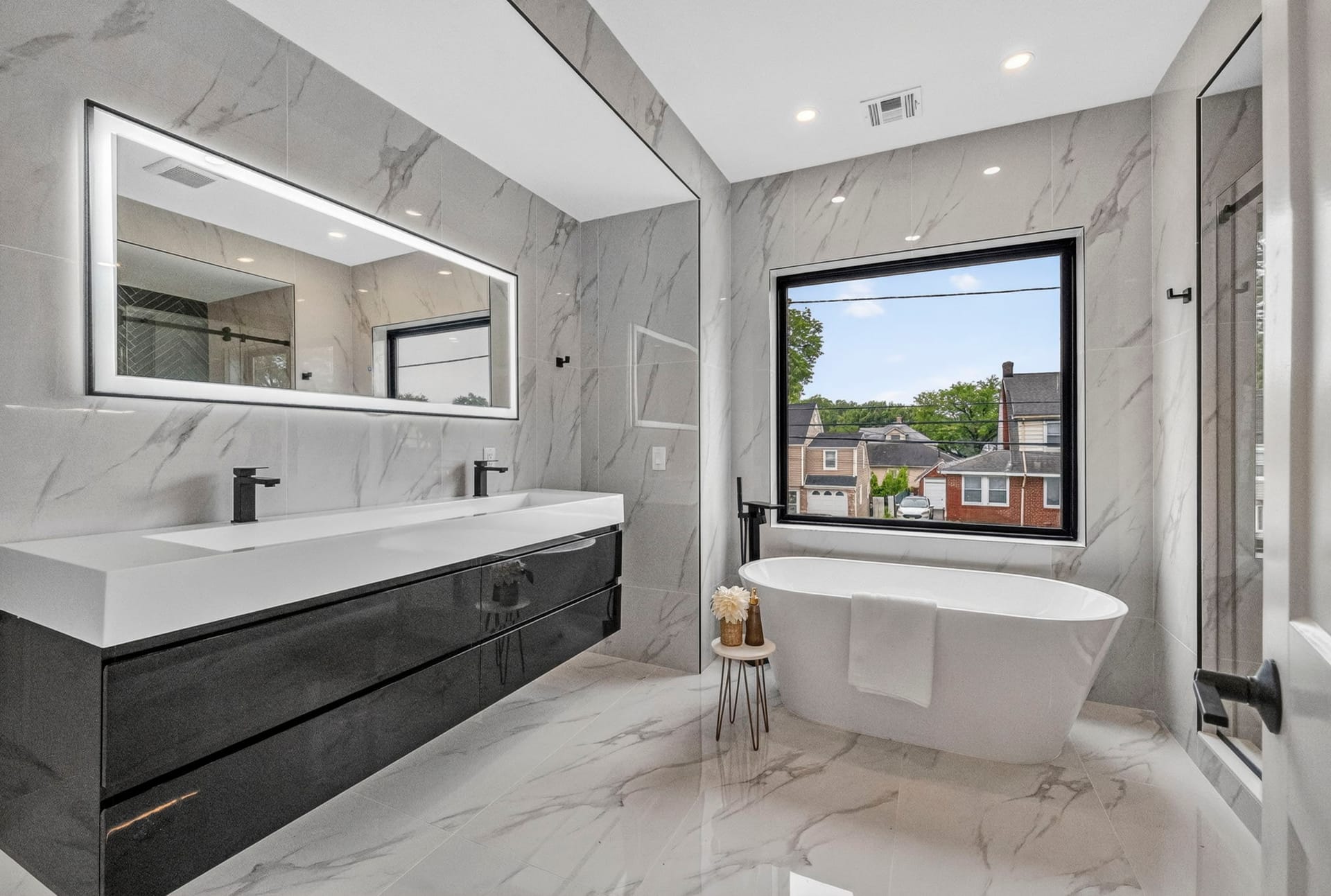 Primary bathroom with a marble double vanity and freestanding soaking tub