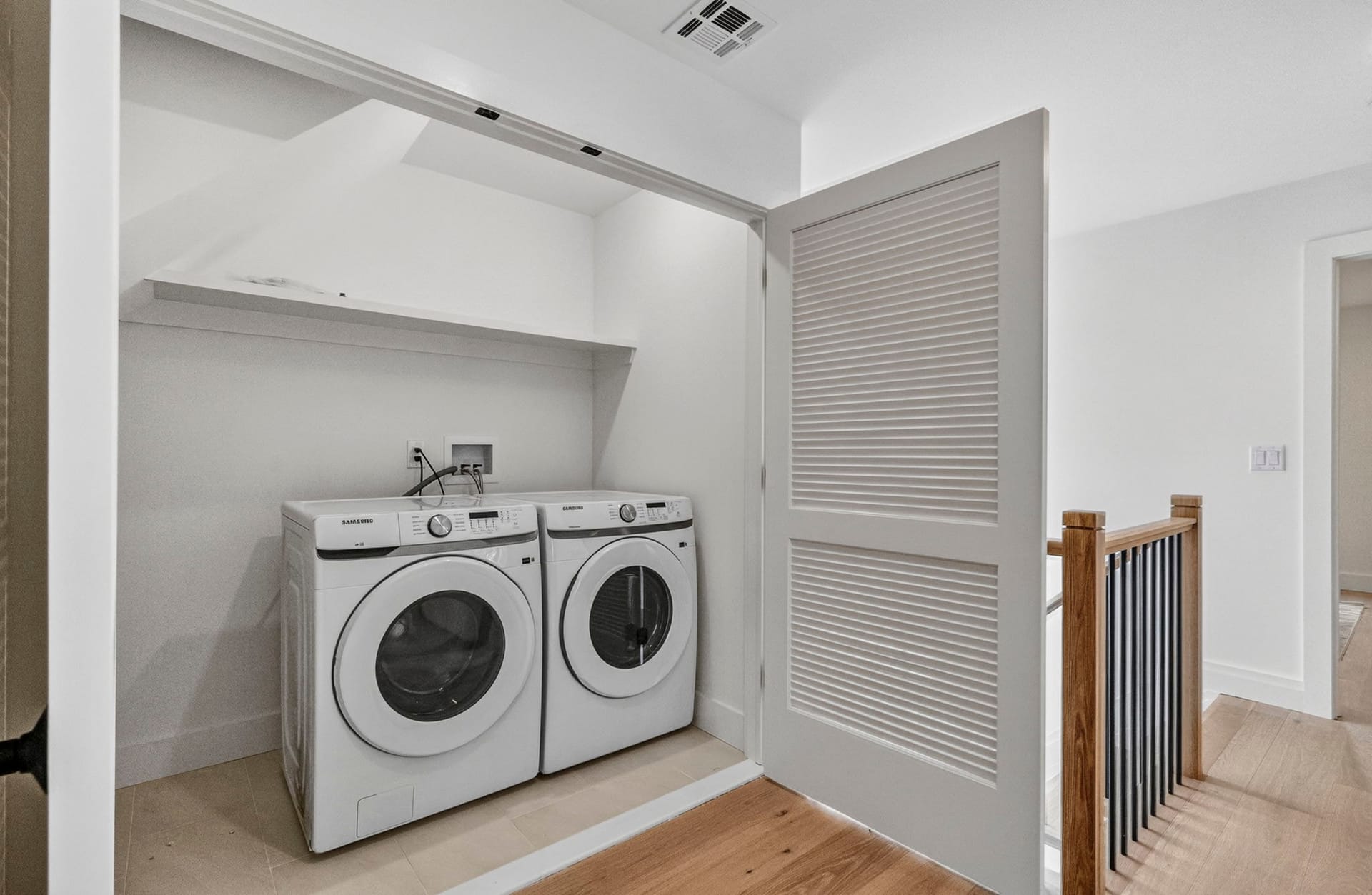 Upstairs laundry closet with a stacked washer and dryer