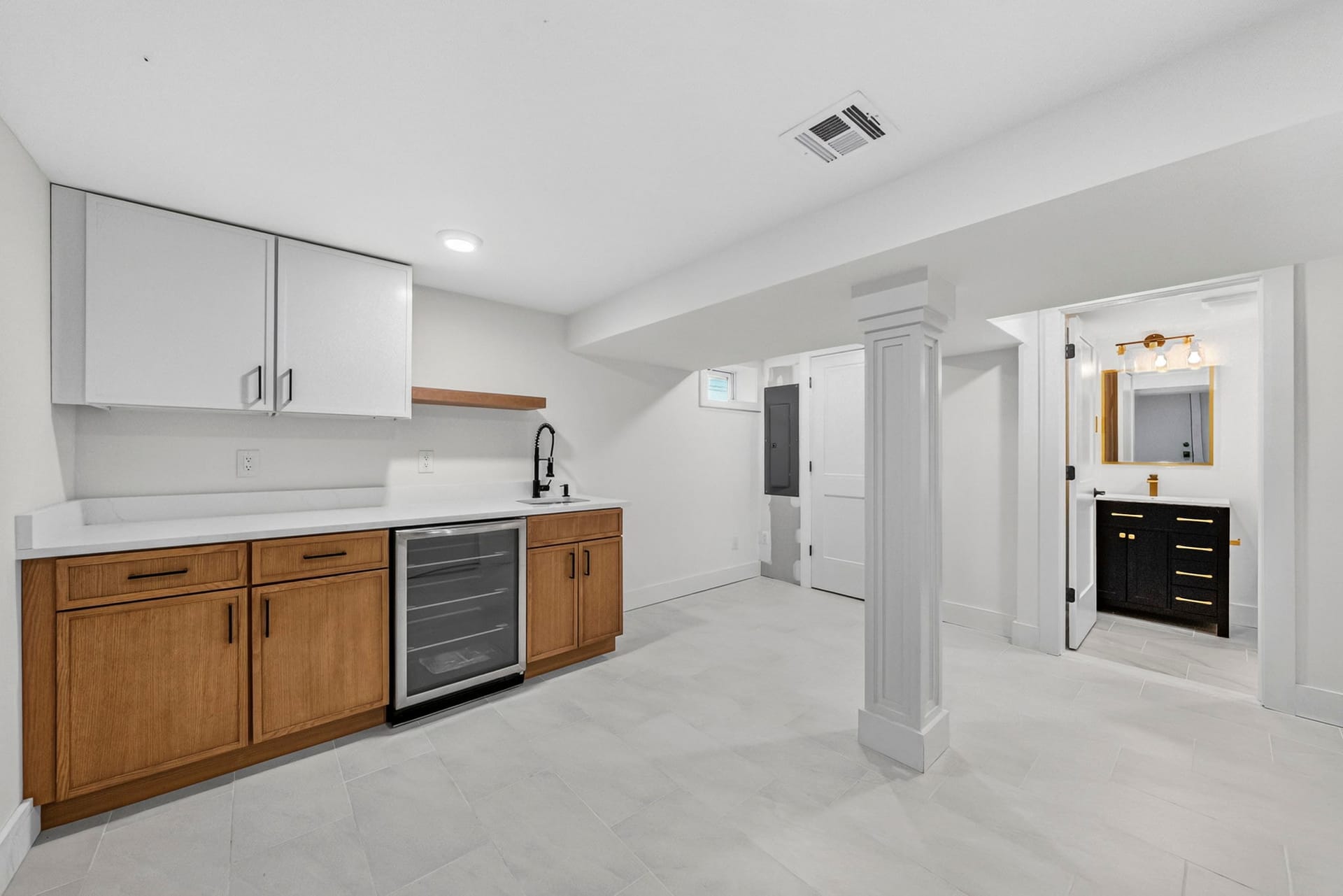Basement wet bar with a wine refrigerator and a view to the laundry and bath