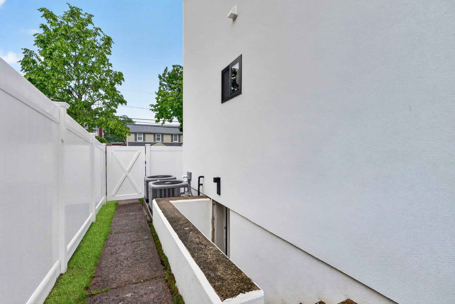 Side yard walkway with fencing and exterior utility units