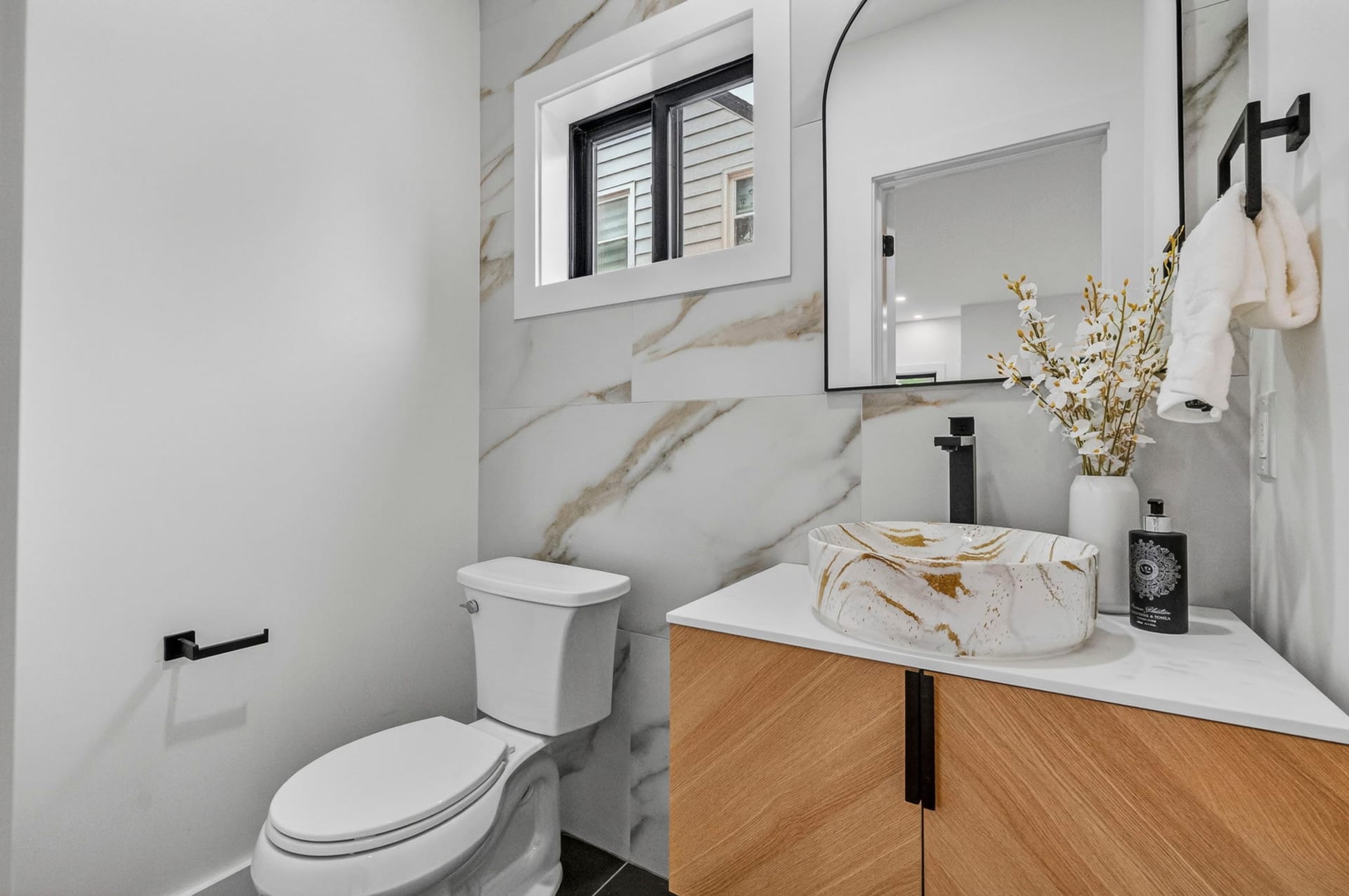 Powder room with marble-look tile and a floating wood vanity