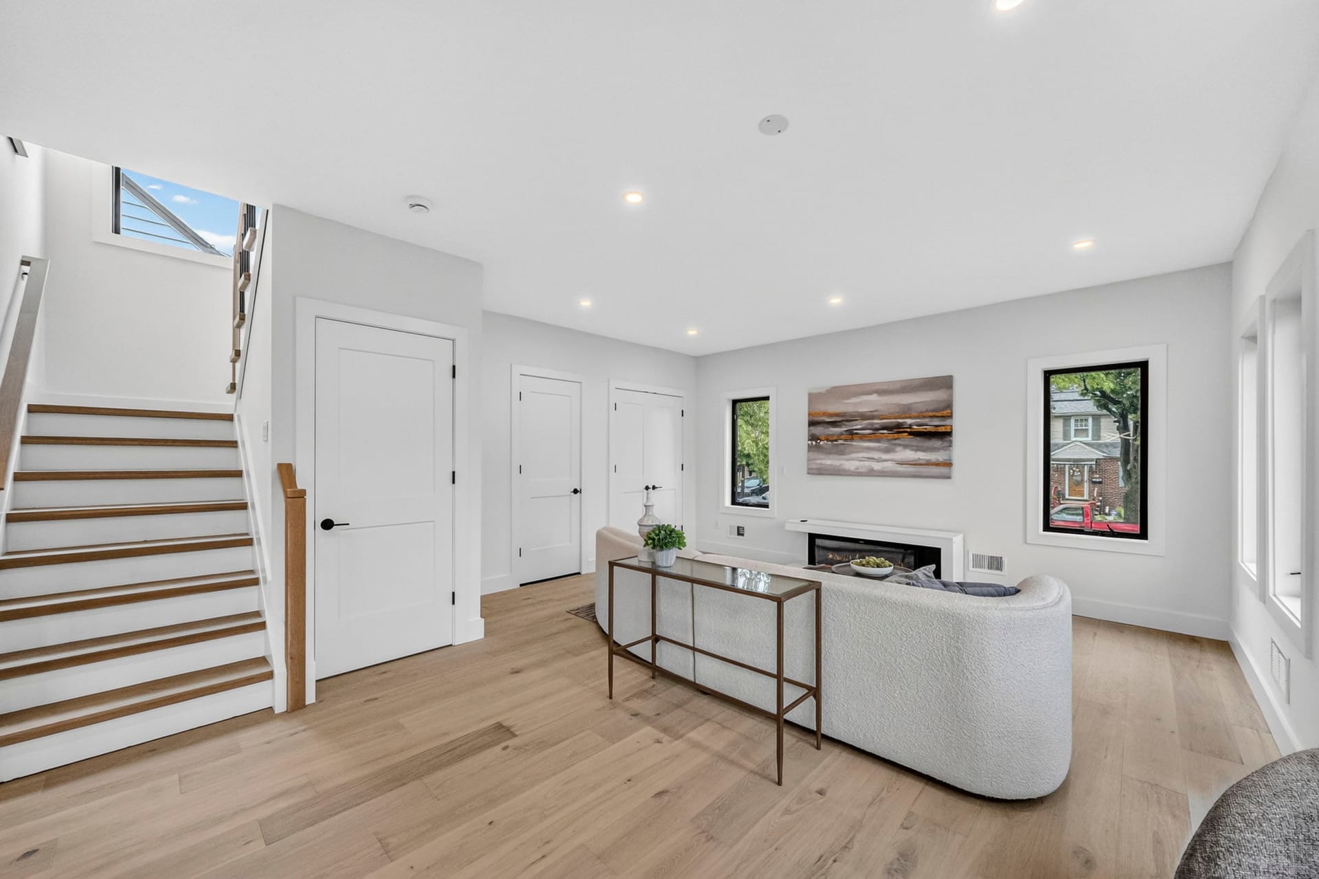 Entry foyer with the staircase, console table, and fireplace beyond