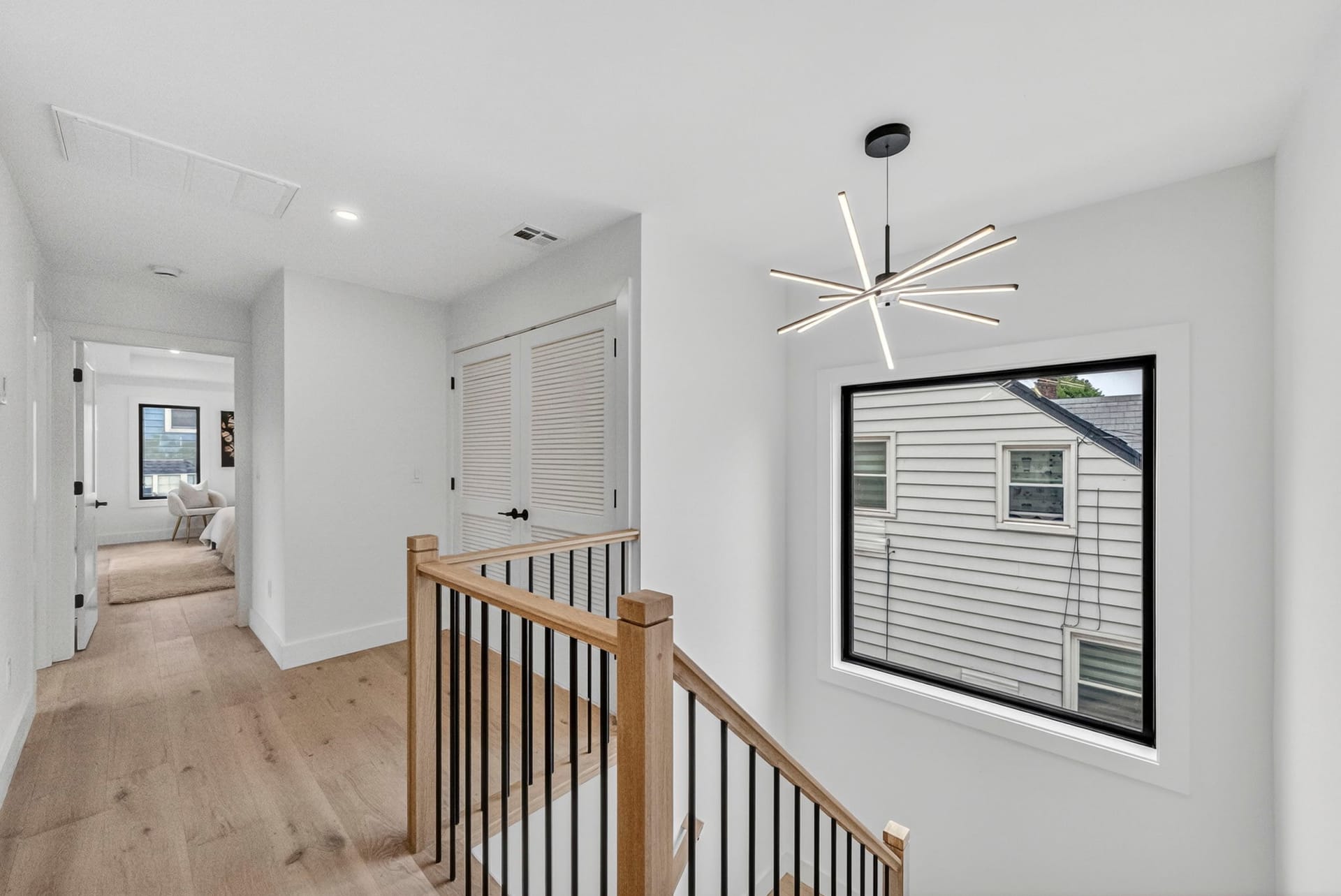 Upstairs hallway landing with a modern chandelier