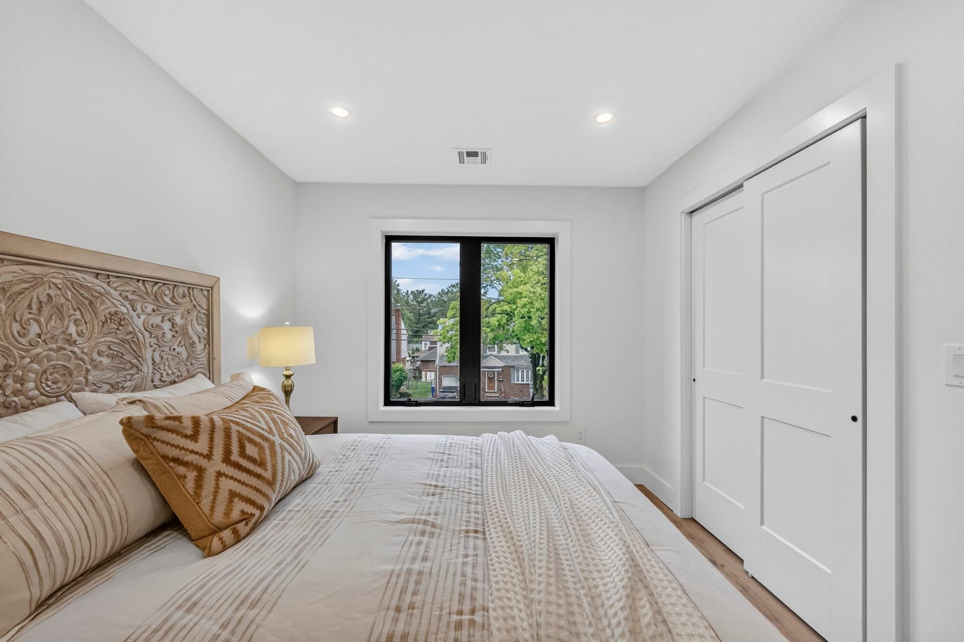 Bedroom with an ornate wood headboard and closet